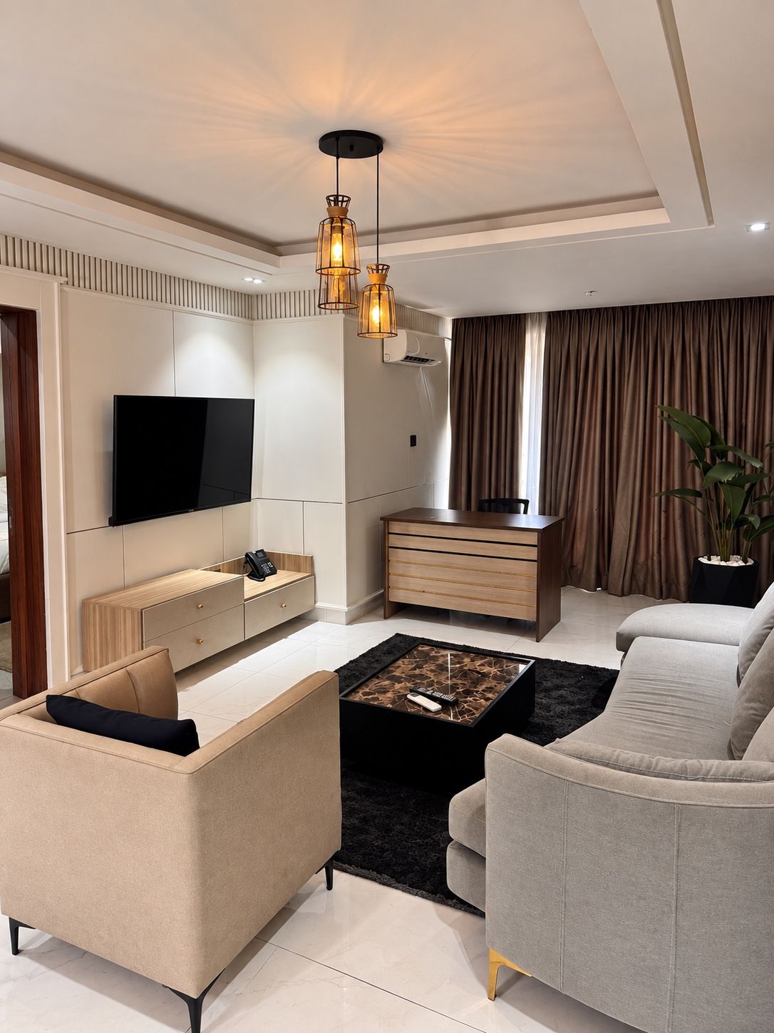 Furnished living room with TV wall and lounge seating